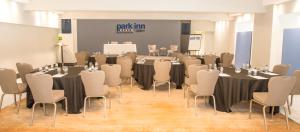 a conference room with tables and chairs and a screen at Park Inn by Radisson Bournemouth in Bournemouth