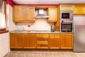 uma cozinha com armários de madeira e um frigorífico de aço inoxidável em PERRATZU LANDARBIDE-Ideal parejas em Aia