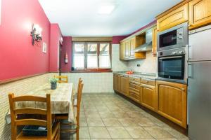 cocina con mesa y pared roja en PERRATZU LANDARBIDE-Ideal parejas en Aia