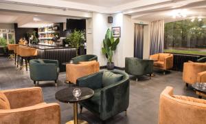 a waiting room with chairs and tables and a bar at Park Inn by Radisson Bournemouth in Bournemouth