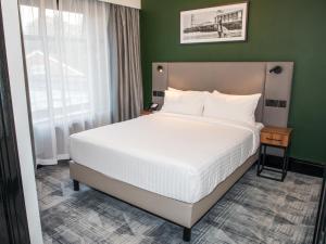 um quarto com uma cama e uma parede verde em Park Inn by Radisson Bournemouth em Bournemouth