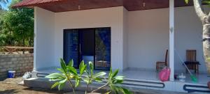 uma casa com uma porta e uma planta na frente em Giri Homestay em Amed