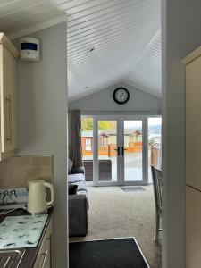 a kitchen with a living room with a clock on the ceiling at V+B Hygge in Windermere +28 photos