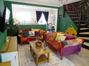 una sala de estar con 2 sofás y una escalera en Havana House - Luxury Property Near Harbour en Weymouth