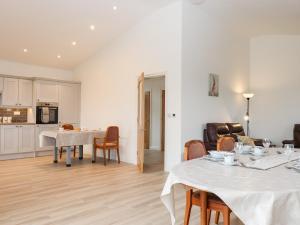 a kitchen and living room with a table and chairs at The Linhay in Crediton