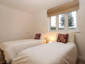 2 weiße Betten in einem Zimmer mit Fenster in der Unterkunft The Linhay in Crediton
