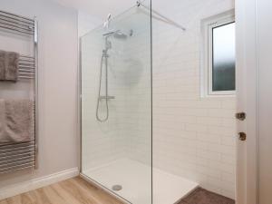 a bathroom with a shower with a glass door at The Linhay in Crediton
