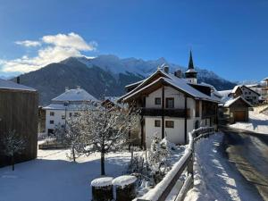 a snow covered village with a church and mountains at Casa Vanellus / Vignogn / Val Lumnezia / near Laax in Vigens