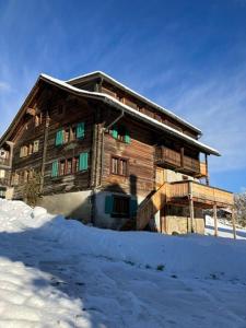 a wooden house with snow in front of it at Casa Vanellus / Vignogn / Val Lumnezia / near Laax in Vigens
