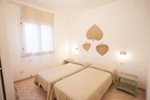 two beds in a white room with hearts on the wall at Appartamenti Villa Anna - Goelba in Capoliveri