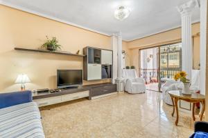 salon z telewizorem i kanapą w obiekcie Sunflower Alhambra w mieście Santa Pola