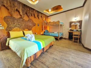 a bedroom with a large bed with a wooden wall at Tamnanpar Resort in Ban Phe