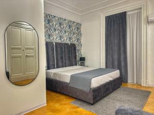 a bedroom with a large bed and a mirror at Boutique Rooms B&B in Catania