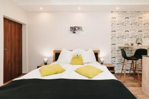 1 dormitorio con 1 cama grande con almohadas amarillas en Oliver Apartman, en Makó