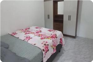 1 dormitorio con 1 cama con una manta floral rosa en Apartamento Superior, en Balneário Camboriú