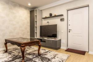 a living room with a table and a tv at Starrent Decebal 99F in Chişinău