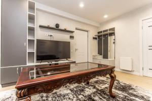 a living room with a large tv and a coffee table at Starrent Decebal 99F in Chişinău