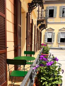 a row of tables and chairs on a street with flowers at Casa Gambusso historical house magnificent Lake View in Verbania