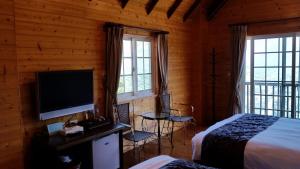 a bedroom with a bed and a flat screen tv at Qingjing Xiaozhu in Renai