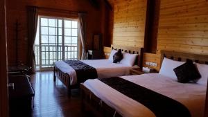 a hotel room with two beds and a window at Qingjing Xiaozhu in Renai
