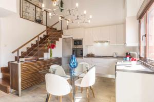 a kitchen and dining room with a glass table and white chairs at La Sierra I by SkyKey in Los Molinos