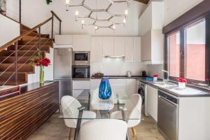 a kitchen with a glass table and white cabinets at La Sierra I by SkyKey in Los Molinos