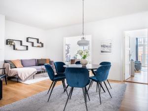 uma sala de jantar com uma mesa e cadeiras azuis em Sanders Leaves - Chic Three-Bedroom Apartment In Downtown Copenhagen em Copenhague