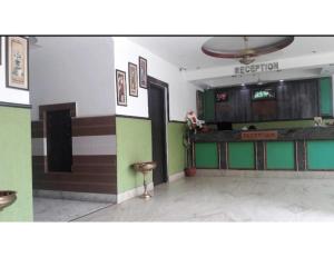 hol restauracji z zielonymi i brązowymi ścianami w obiekcie Hotel Om Karan Katra w mieście Katra