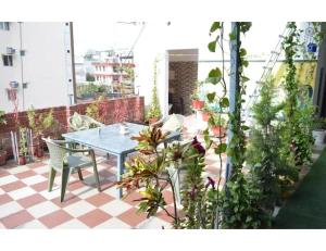 une table et des chaises sur une terrasse agrémentée de plantes dans l'établissement Hotel Om Karan Katra, à Katra