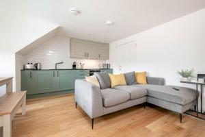 een woonkamer met een bank en een keuken bij Skye Sands - Balgove Penthouse Residence - St Andrews in St Andrews