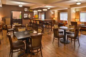 a restaurant with tables and chairs and a bar at Wingate by Wyndham Steubenville in Steubenville