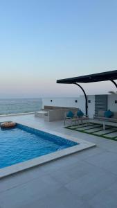 a swimming pool with a view of the ocean at The Ocean Villa in Fujairah