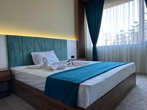 a bedroom with a large bed with a blue headboard at Kançul Hotel Taştepeler in Urfa