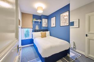 1 dormitorio pequeño con paredes azules y 1 cama en Seaside Retreat sleeping 4 en Ilfracombe