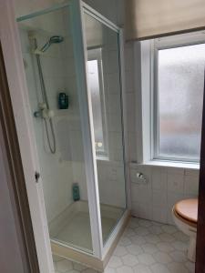 een douche met een glazen deur in een badkamer bij Witton house in Blackpool