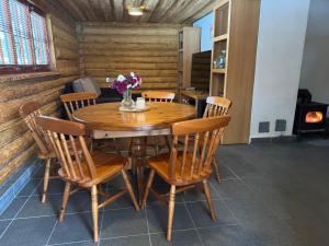 a dining room with a wooden table and chairs at Salmiņu Pirtsmāja ar relaksējošu baļļu in Pastva Barbern
