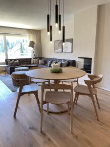 ein Wohnzimmer mit einem Tisch, Stühlen und einem Sofa in der Unterkunft Val Signina 6-21 in Laax