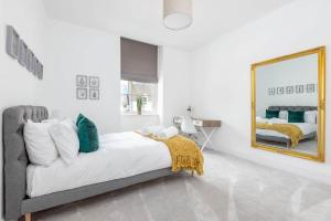 a bedroom with a large bed and a mirror at Skye Sands - The Old Course Residence - St Andrews in St. Andrews