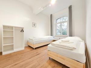 a bedroom with two beds and a window at RAJ Living - 300m2 Loft with 7 Rooms - 15 Min Messe DUS & Old Town DUS in Düsseldorf