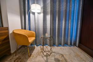 a chair and a lamp in front of a curtain at 54 Floor Palm & Sea View Dubai Marina. LUX / NEW in Dubai