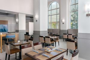 um restaurante com mesas, cadeiras e janelas em Hilton Garden Inn Charlotte Uptown em Charlotte