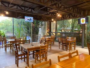 un restaurante con mesas de madera y sillas de madera en Los Lagos Resort Hotel en Capiatá