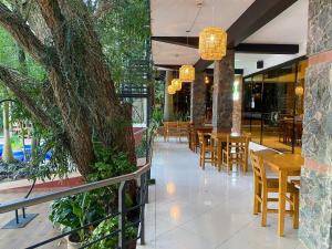 a restaurant with wooden tables and chairs and trees at Los Lagos Resort Hotel in Capiatá