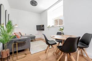 sala de estar con mesa, sillas y sofá en Skye Sands - The Eden Residence - St Andrews en St Andrews