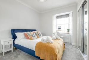 a bedroom with a blue bed with towels on the end of it at Skye Sands - South Street Residence - St Andrews in St. Andrews