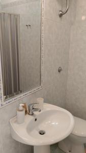 bagno con lavandino, servizi igienici e specchio di B&B Napoli Campagnari a Napoli