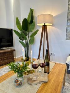 巴特諾因阿爾－阿爾韋勒的住宿－Boutique L´AHRpartement Ahr-Terrasse-Zentral，一张桌子,上面放着两杯葡萄酒和一盏灯