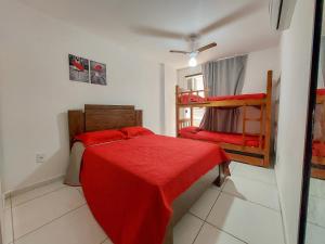 1 dormitorio con 2 literas y manta roja en Prainha Paradise, en Arraial do Cabo