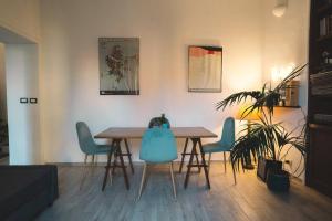 a dining room with a wooden table and blue chairs at Vaticano/Trastevere Floreal Suite in Rome