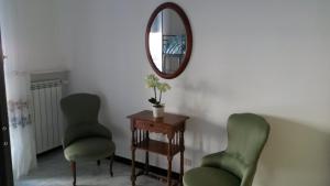 a room with two green chairs and a mirror at Appartamento Cavour 15 in Bogliasco